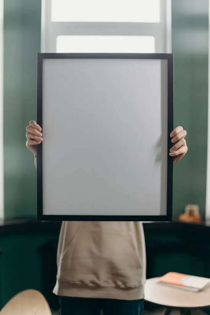 Person Holding White and Black Frame